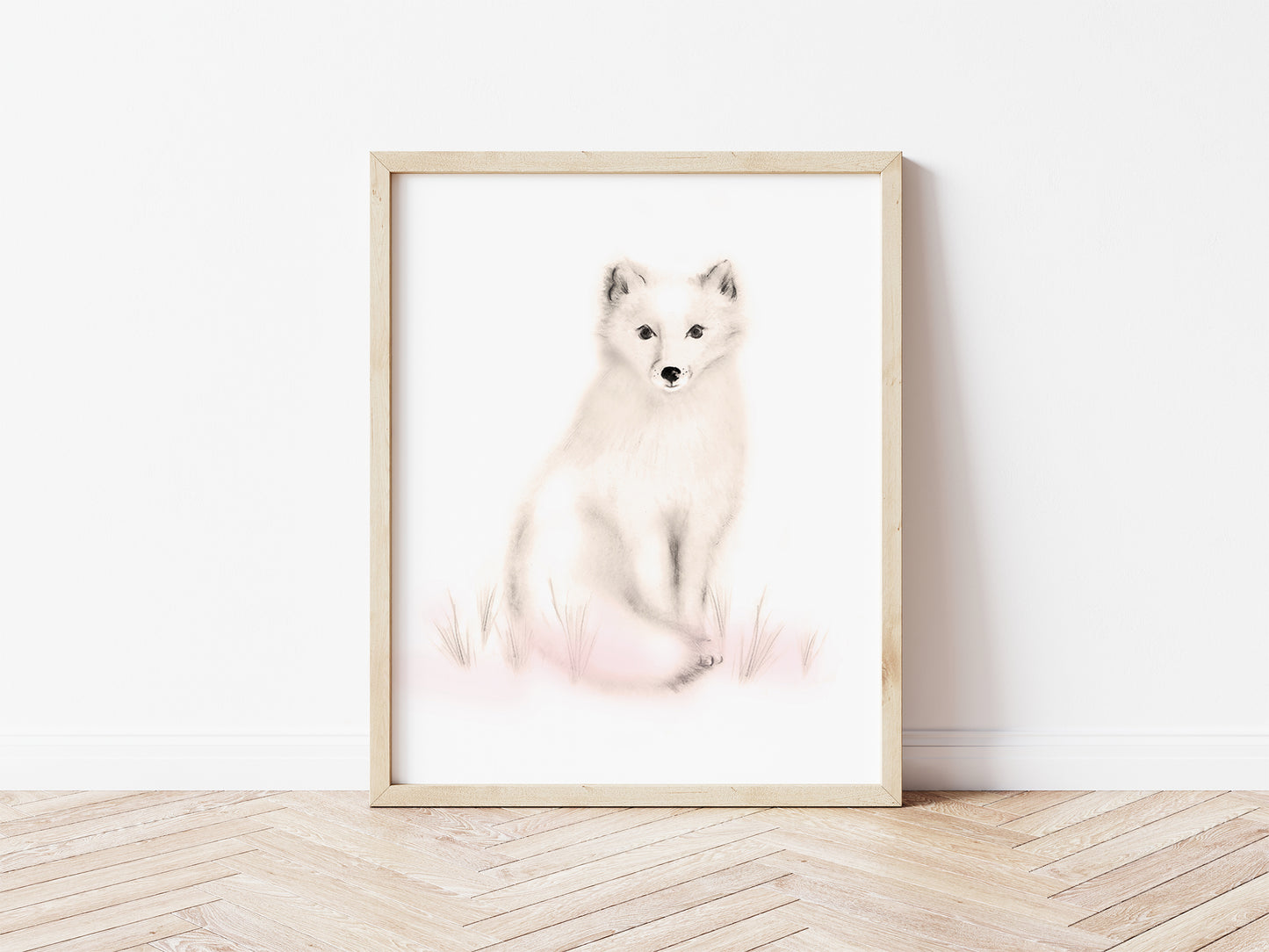 Drawing of an arctic snow fox in tones of sepia beige and blush pink on a plain, white background. The print is in a light wood frame and sits on a wood floor. Studio Q - Art by Nicky Quartermaine Scott