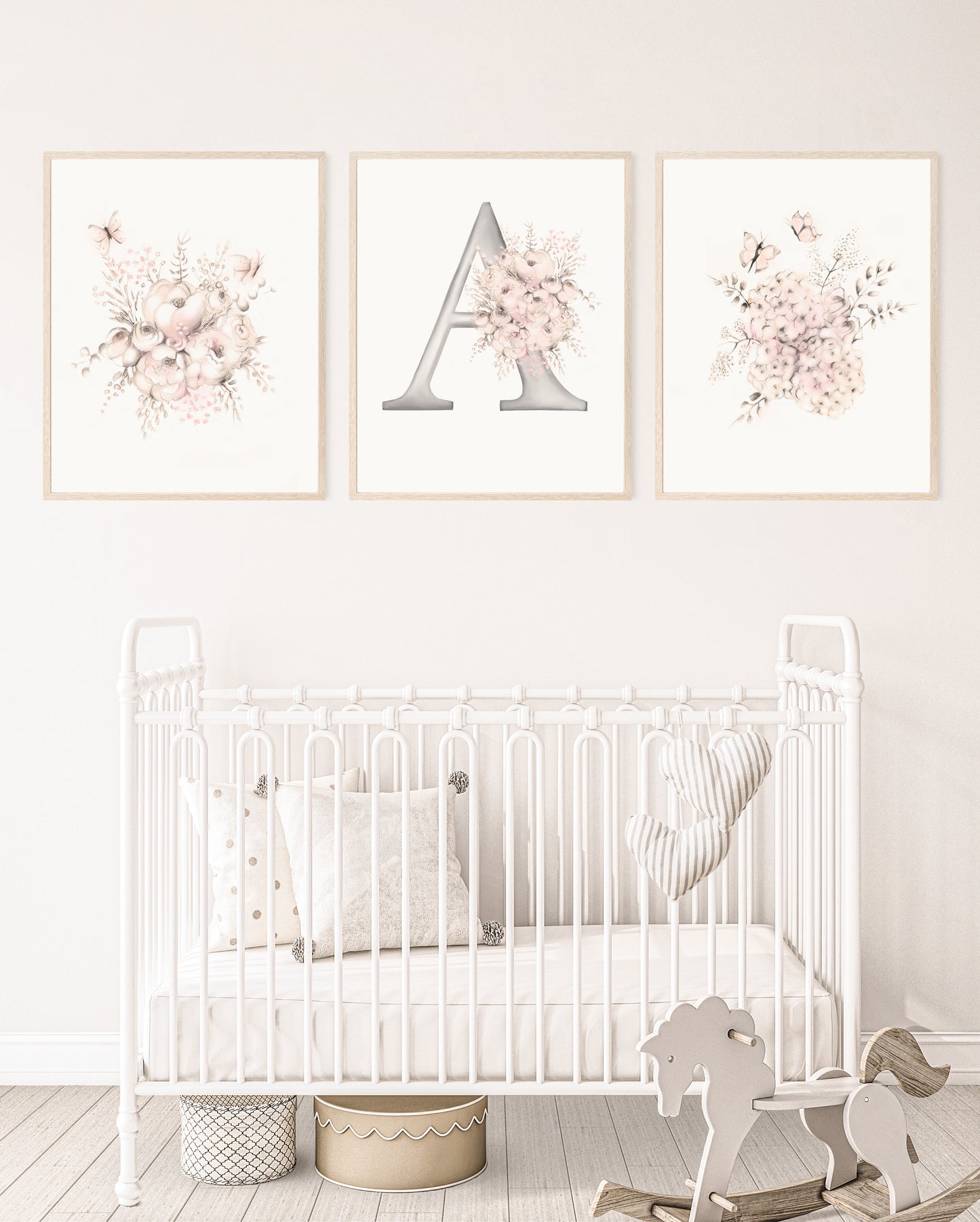 Set of three flower and butterfly sketches in tones of beige and blush pink. Center print has a letter A designed with flowers. Prints are mounted in wood frames and are hung above a white crib in a pink baby girl's nursery - Studio Q - Art by Nicky Quartermaine Scott