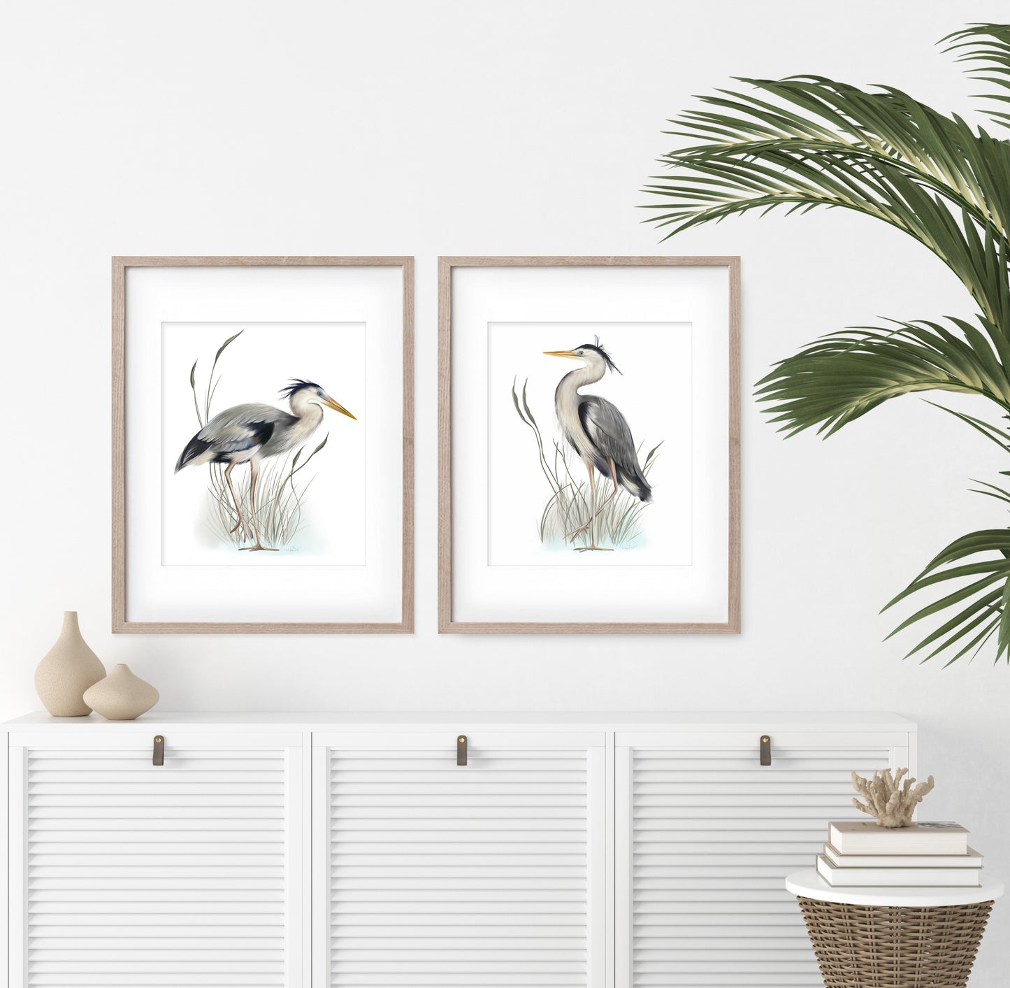 Set of 2 Great Blue Heron Birds in tall grasses art illustration prints on white in wood frames hanging above a white credenza in a living room - Studio Q - Art by Nicky Quartermaine Scott